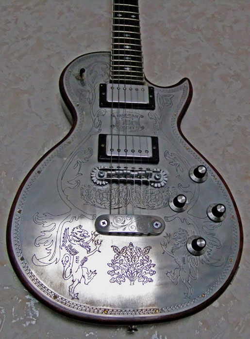 Degay Guitars - detail of 6-string electric metal front with griffins engaving